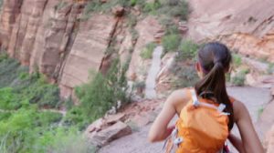 stock-footage-hiker-hiking-in-zion-national-park-happy-woman-hiker-trekking-on-walking-path-in-zion-canyon (1)